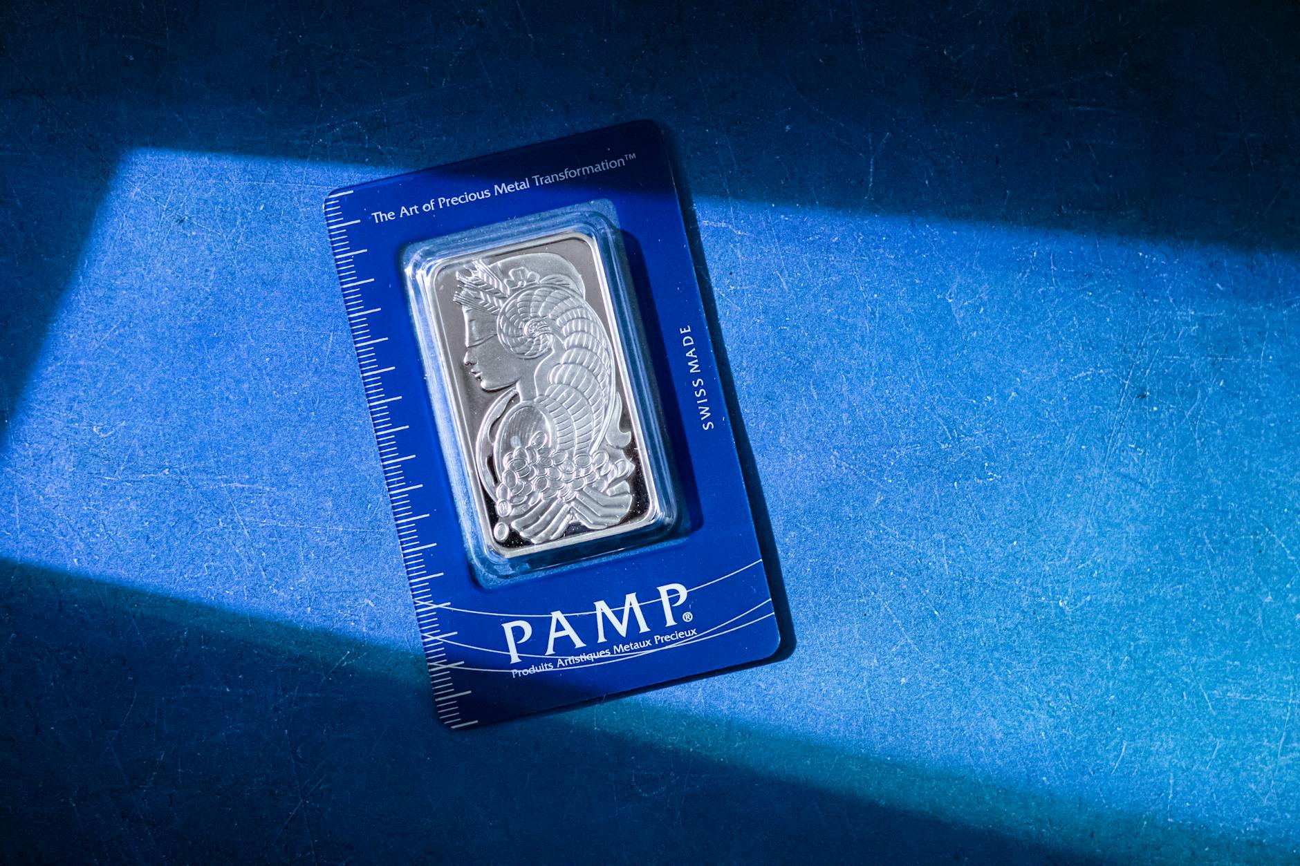 Silver bullion bars displayed on a dark surface showing fine silver purity and minting details