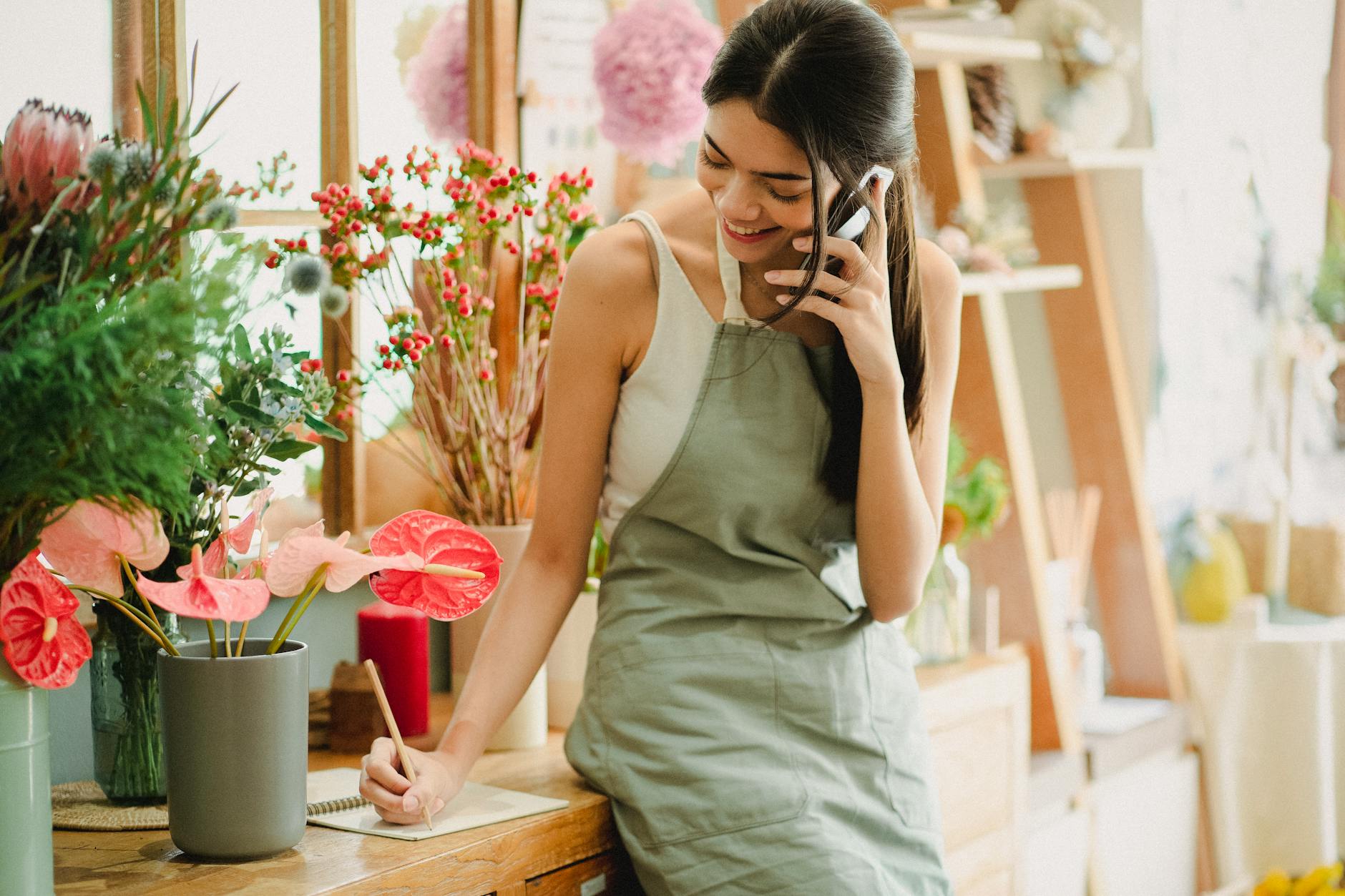 Small business owner looking at phone while managing social media content