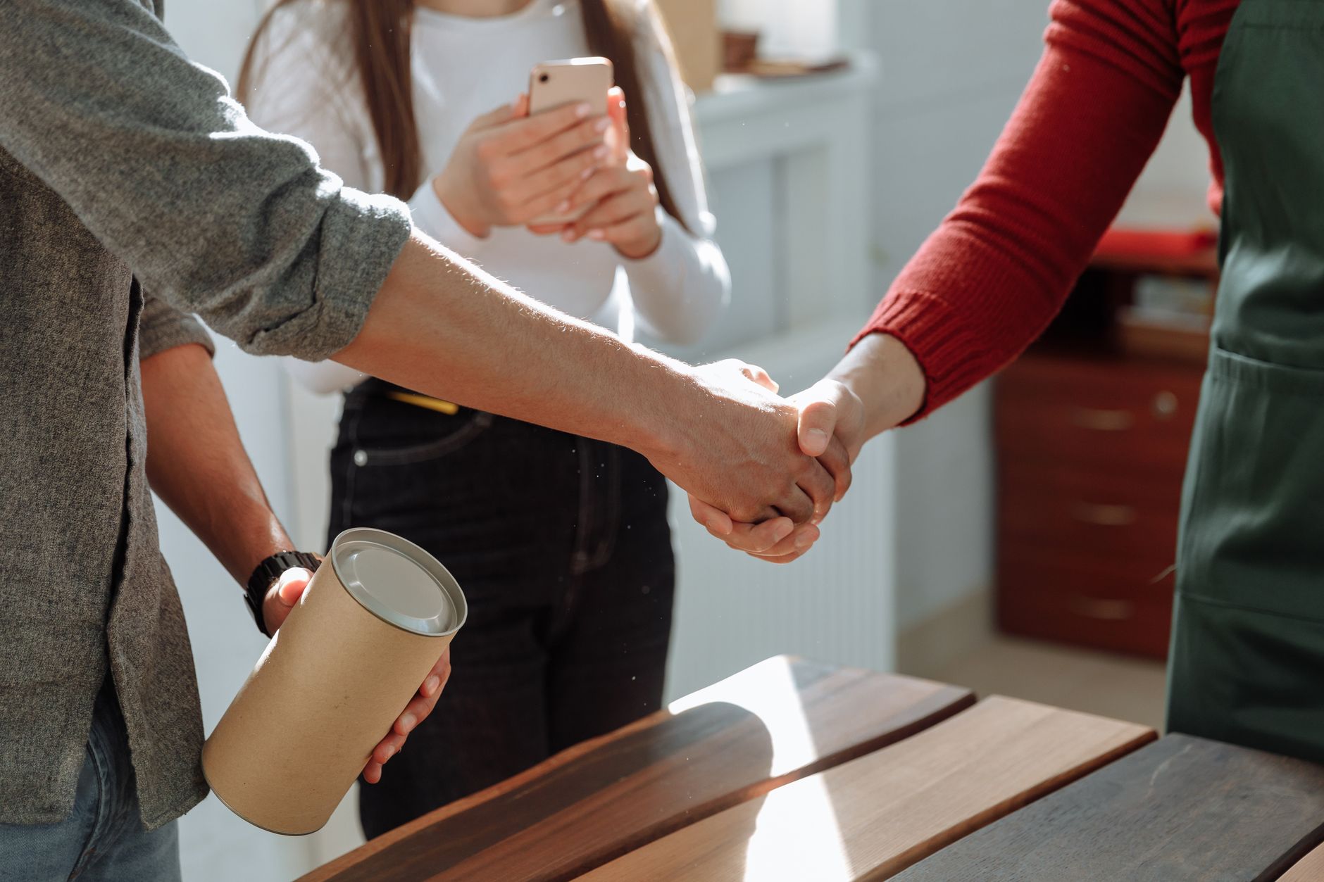 Business owner shaking hands with a returning customer at a local shop
