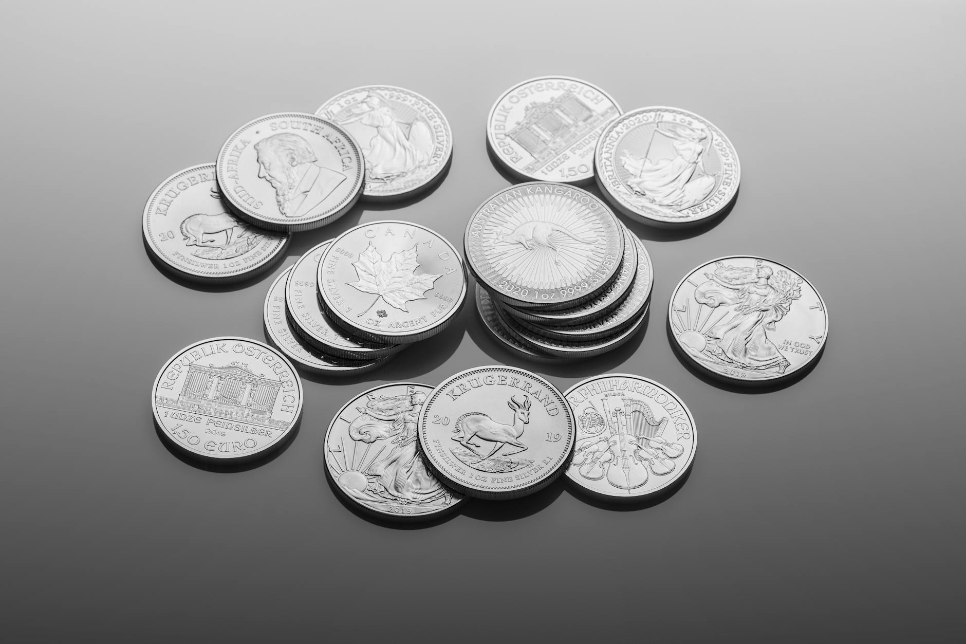 Silver coins arranged on a dark reflective surface