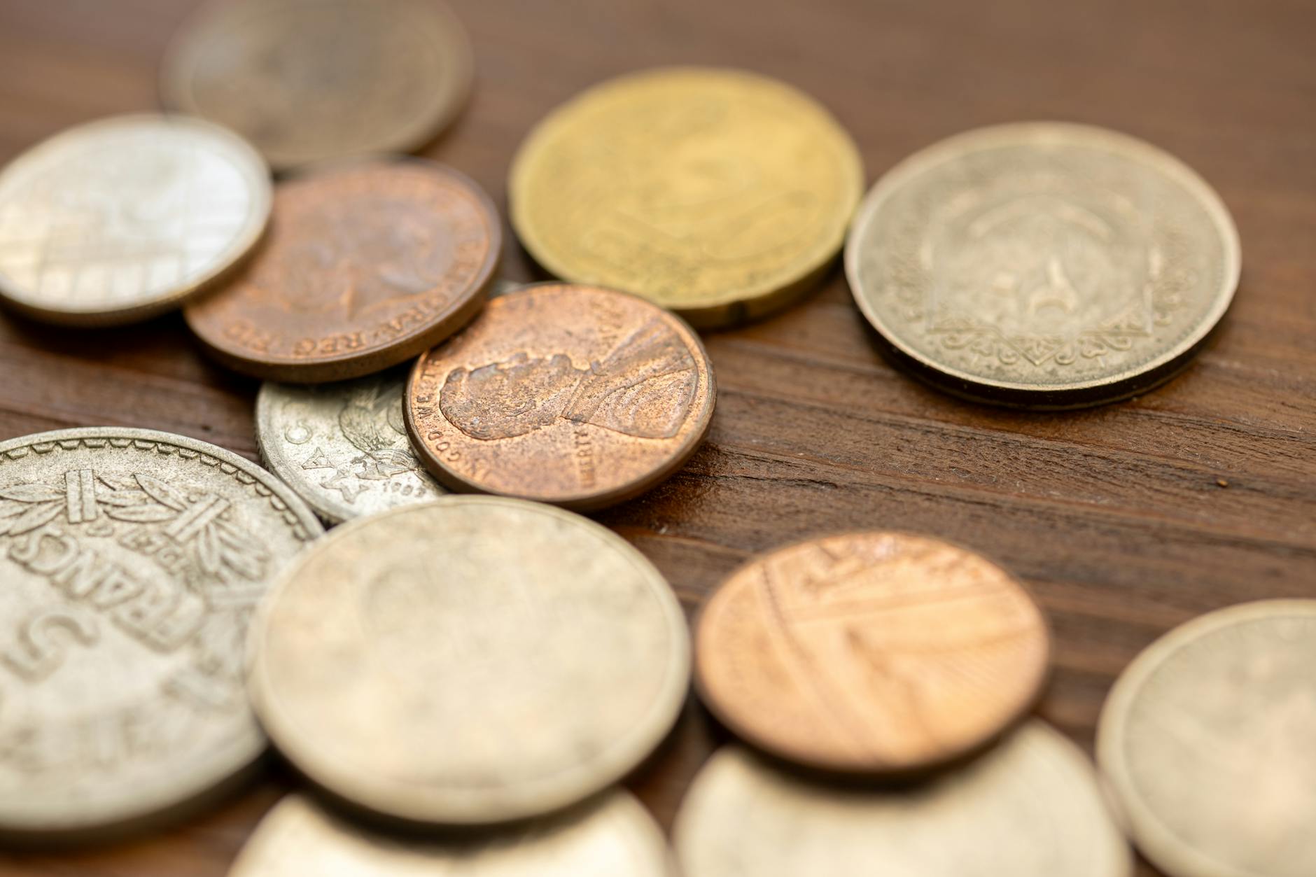 Ancient silver coins displayed on a dark surface, showing historical currency