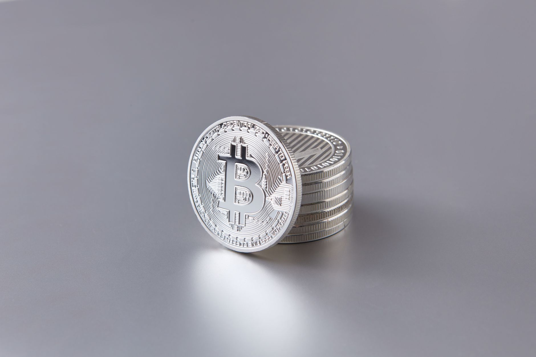 A short stack of silver bullion coins on a plain light surface.