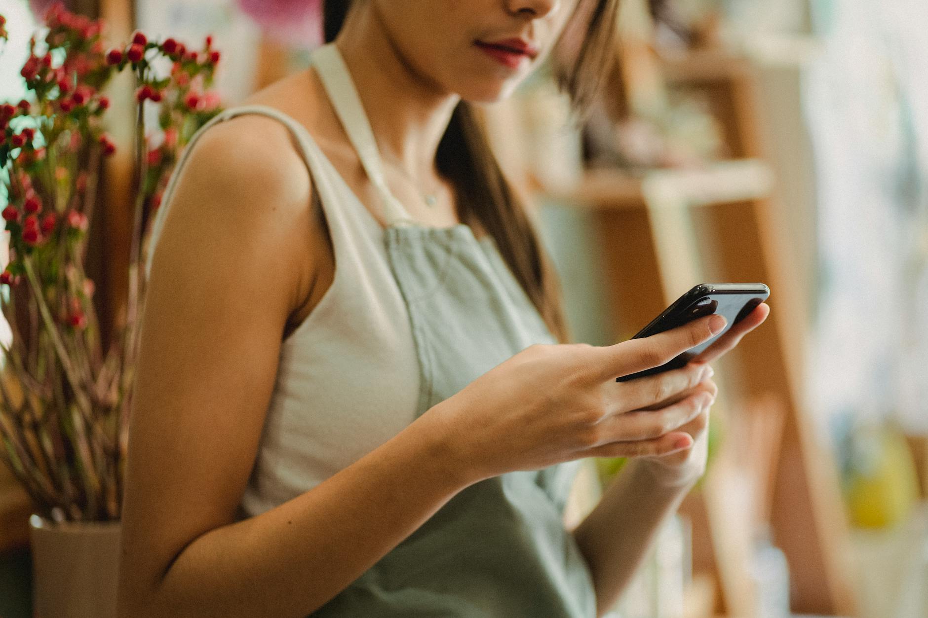 Local business owner reviewing text message marketing on smartphone