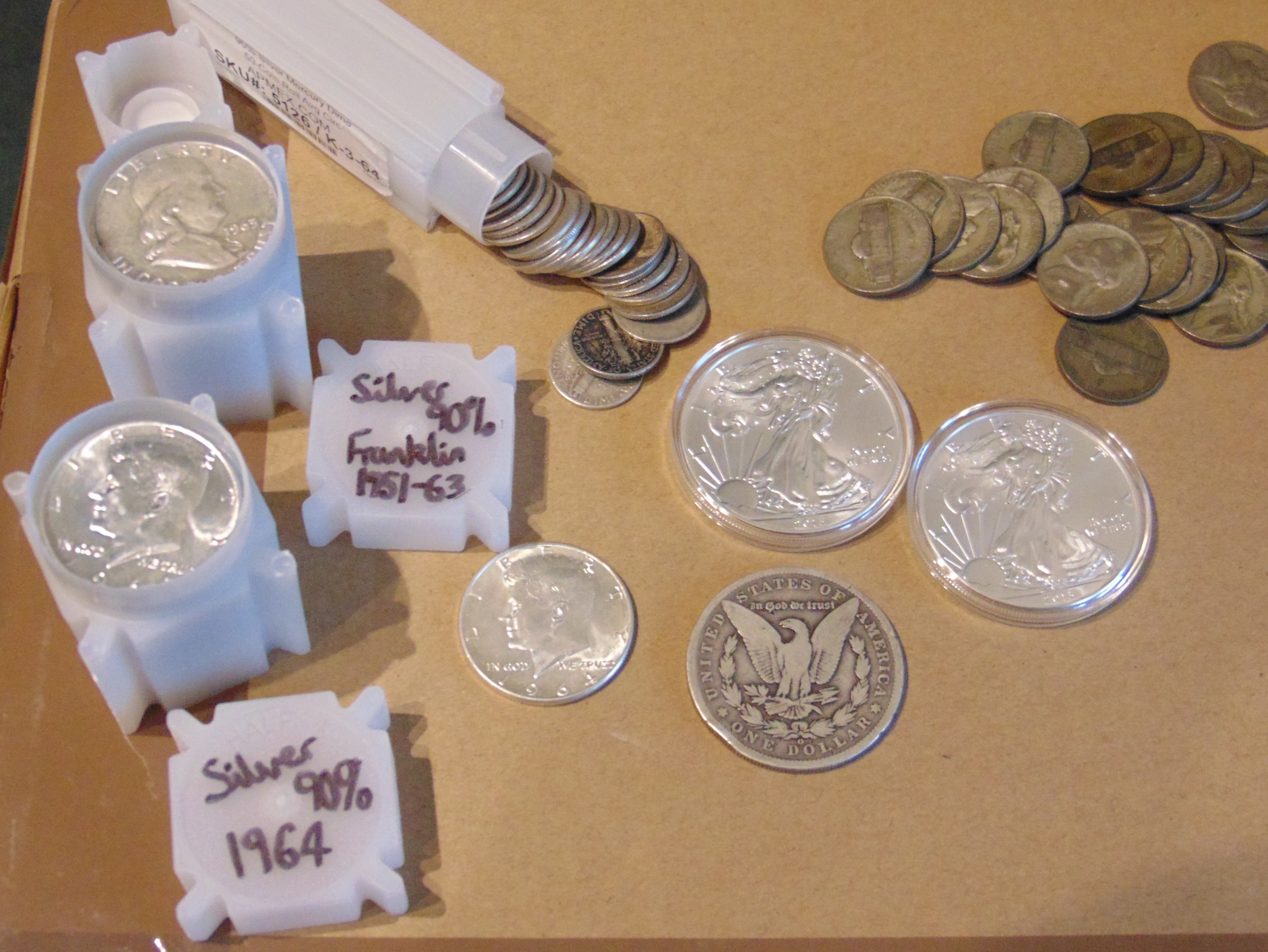 Various types of American silver coinage including Morgan dollars, Walking Liberty halves, Mercury dimes, and silver rounds