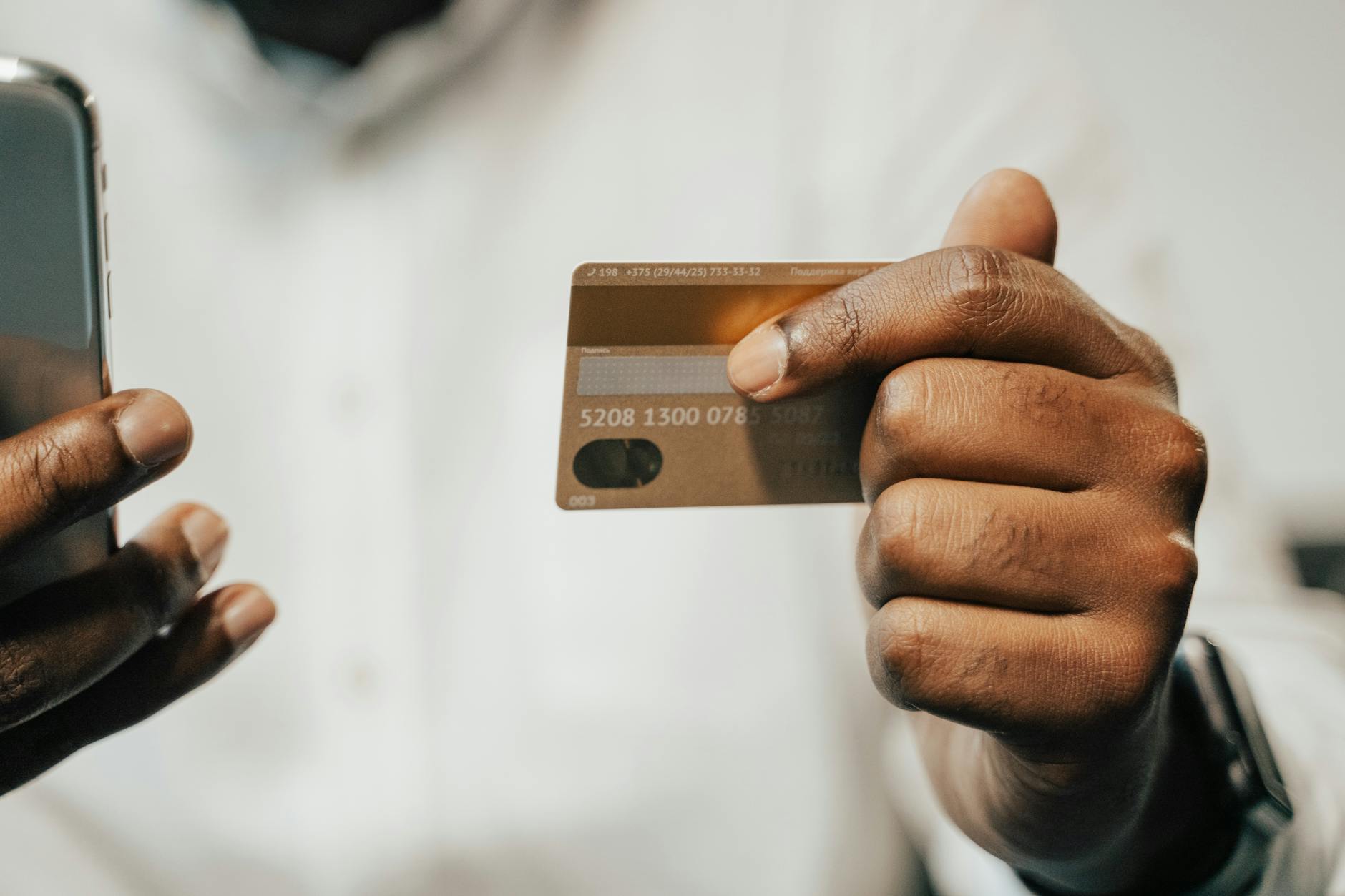 Person holding a credit card and smartphone representing secure online silver purchasing