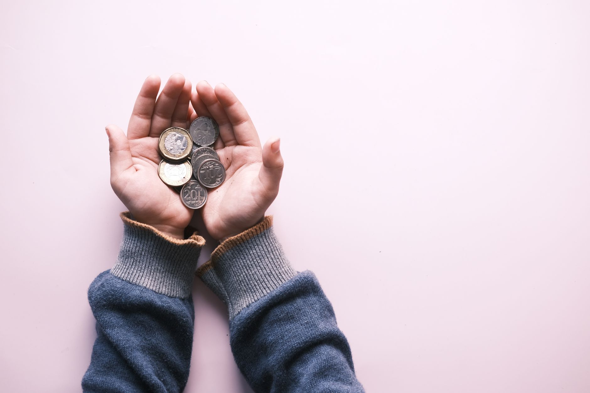 Person holding silver round coins in hand showing physical silver investment