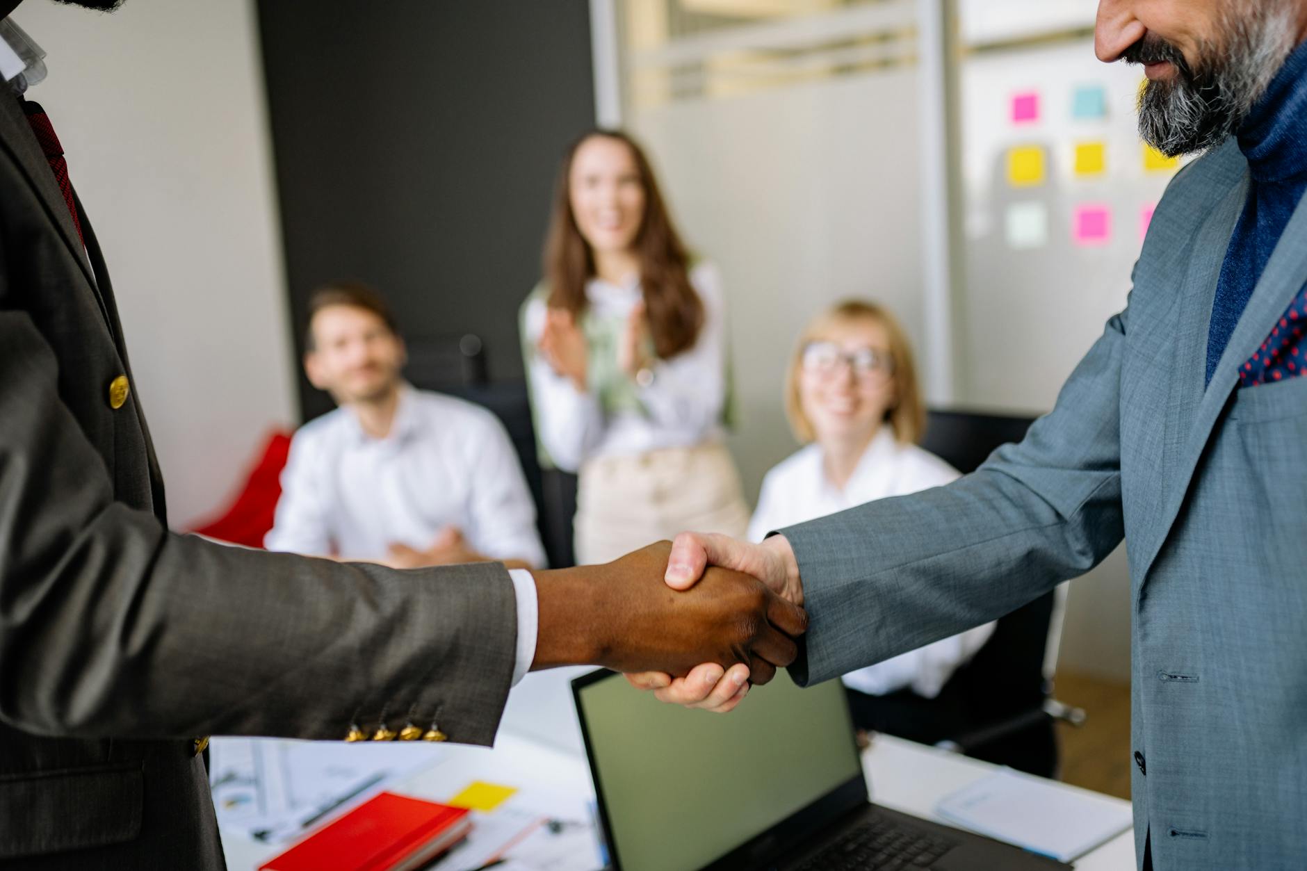 Two business owners shaking hands, representing a word-of-mouth referral relationship